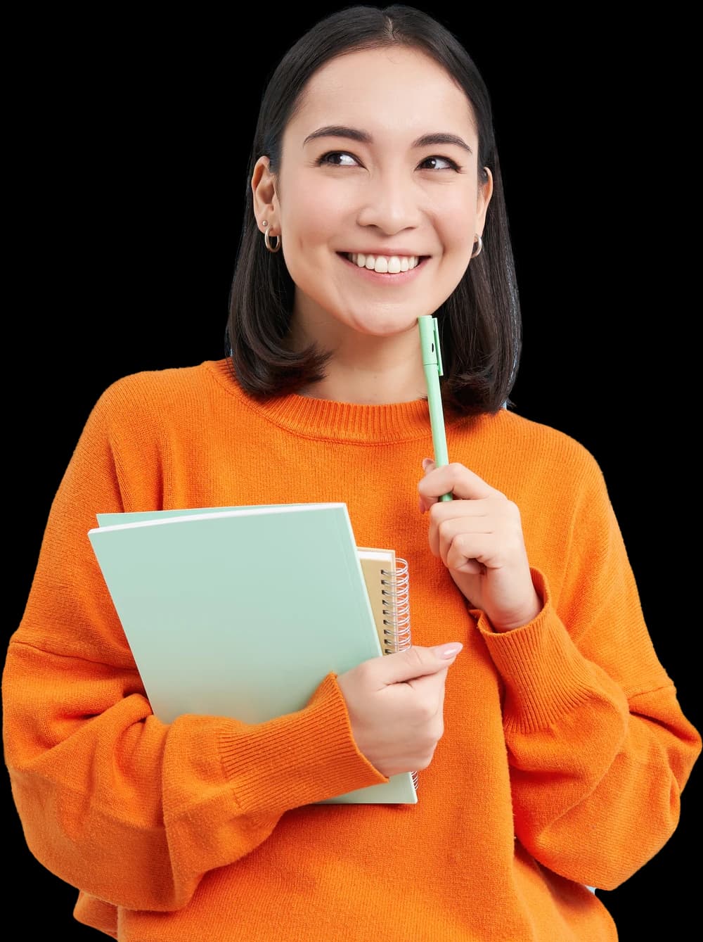Perempuan bersweter oranye tersenyum sambil memegang buku catatan